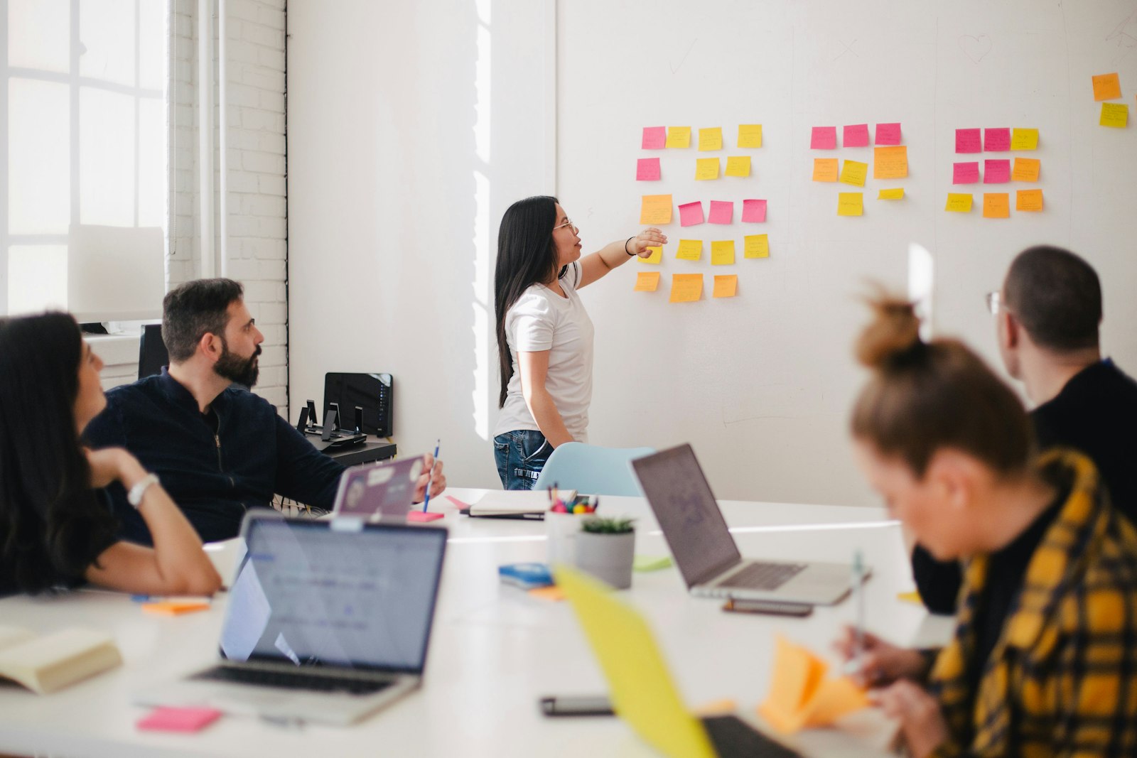 Creative team reviewing campaign boards on a warm-toned wall.