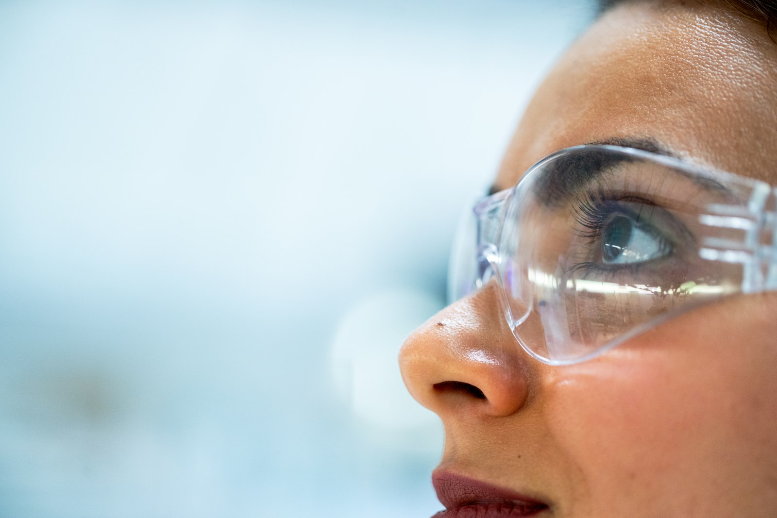 Bench scientist pipetting into a rack in a clean, warm-lit lab.