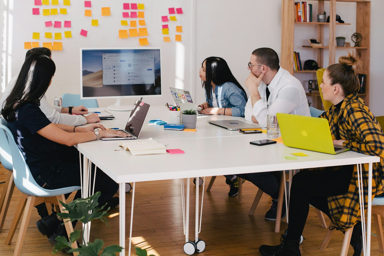 Sales team on a call with a pipeline board in soft afternoon light.